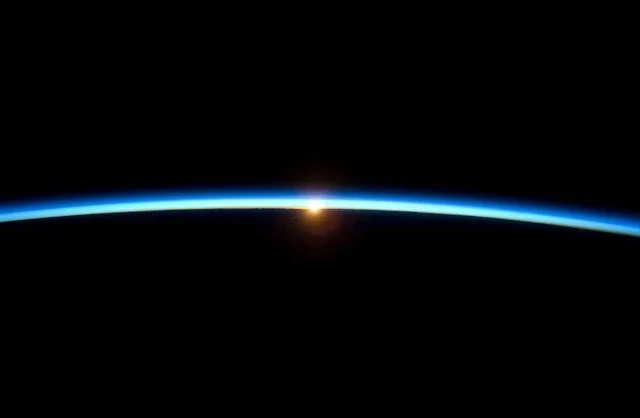 A sun just beginning to rise behind a dark planet. A sun just beginning to rise behind a dark planet.