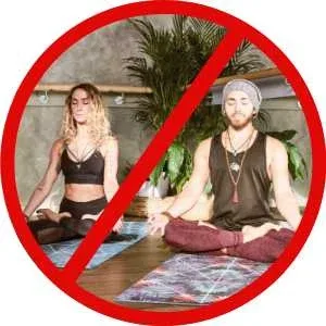 A crossed out red circle on top of two young people meditating on yoga mats looking cool A crossed out red circle on top of two young people meditating on yoga mats looking cool