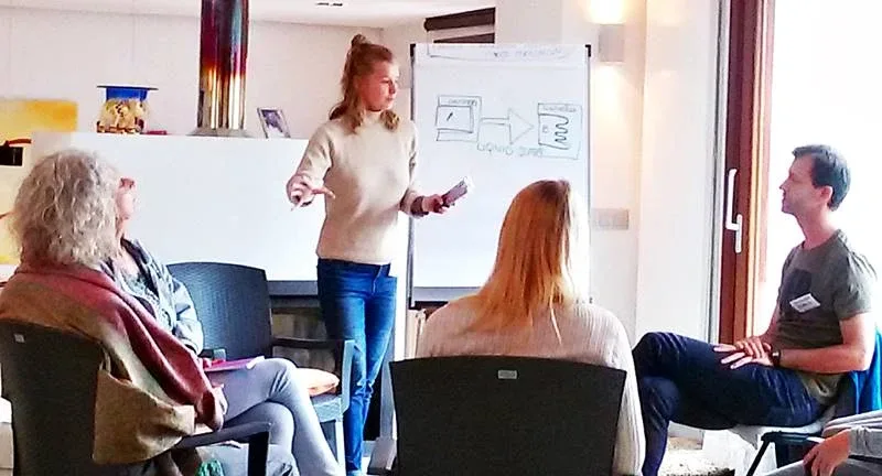 A woman delivering the Map of Liquid States to a group of people sitting in a circle A woman delivering the Map of Liquid States to a group of people sitting in a circle