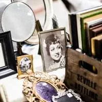 A collection of old things - a black and white photograph, a brooch, a mirror, a magnifying glass and several books A collection of old things - a black and white photograph, a brooch, a mirror, a magnifying glass and several books