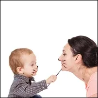 A small child with their face painted like a cat holding a paintbrush that's touching a woman's face that is also painted like a cat A small child with their face painted like a cat holding a paintbrush that's touching a woman's face that is also painted like a cat
