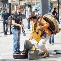 Aman giving money to a busker with a guitar and a drum Aman giving money to a busker with a guitar and a drum